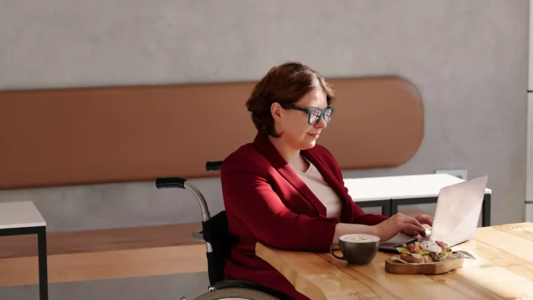 Femme travaillant sur un bureau, avec un café et à manger